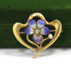 "Art Nouveau/1900 14k yellow gold hand enameling .05 carat natural diamond H in color 1\" x 1\" condition: excellent Beautiful Art Nouveau flower brooch, crafted of 14 karat yellow gold and set with hand enameling and a natural diamond.  The brooch is a nice size, measuring 1\" x 1\", and features a lavender flower delicately detailed in enamel, with a .05 carat natural diamond H in color set at the center.   The brooch is in excellent condition, with no damage to the gemstone or enamel loss.  I Yellow Gold Enamel Brooches, Art Deco Yellow Gold Collectible Brooches, Art Nouveau Enamel Brooch Jewelry, Diamond Flower Brooch As Gift, Diamond Flower Brooch For Gift, Diamond Flower Brooches For Gifts, Yellow Gold Enamel Brooches Hallmarked, Art Deco Yellow Gold Hallmarked Brooches, Elegant Yellow Gold Enamel Brooches