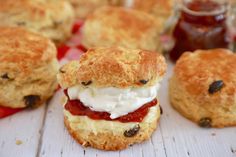 biscuits with jam and cream on them sitting on a table