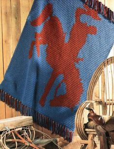 a blue and red blanket sitting on top of a wooden floor next to a chair