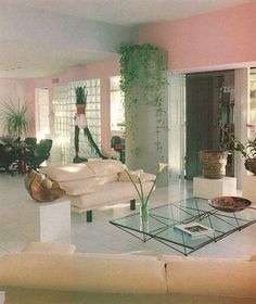 a living room filled with furniture and plants