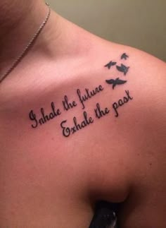 the back of a woman's shoulder with birds flying around it and an inscription that reads