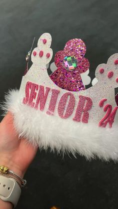 someone is holding up a pink and white princess crown with sequins on it