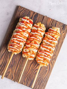 several skewers with sauce on them sitting on a cutting board