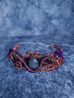 Handmade choker made with copper and purple coated copper wire. encasing a labradorite as the centerpiece with garnet on both sides as well as lapis lazuli, aquamarine and carnelian. adjustable via chain and clasp. Hand Wrapped Purple Copper Wire Jewelry, Purple Metal Choker For Gift, Purple Adjustable Handmade Choker, Adjustable Purple Copper Wire Jewelry, Handmade Purple Copper Wire Necklace, Adjustable Electroformed Purple Jewelry, Adjustable Purple Electroformed Jewelry, Purple Wire Wrapped Copper Wire Necklace, Copper Choker