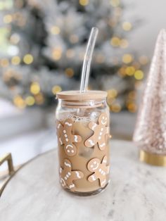 a glass jar sitting on top of a table next to a christmas tree with lights