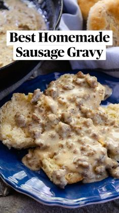 biscuits and gravy on a blue plate next to a skillet with rolls