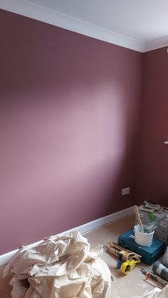 a room that has been painted purple and white with some items on the floor next to it