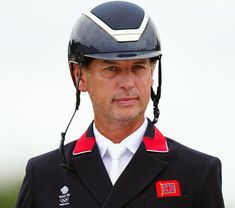 a man wearing a helmet and uniform looks off into the distance