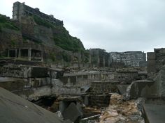 the ruins of an old city with buildings on top of it and trees growing out of them