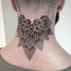 a man's neck with a flower tattoo on it