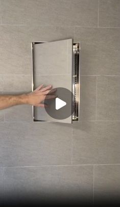 a man is opening the shower door with his hand