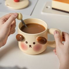 a person is holding a spoon in a coffee cup