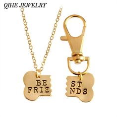 two gold necklaces with the words be friend and dog bone charms attached to them