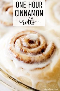 cinnamon rolls with white icing in a glass dish on top of a table and text overlay that reads, one - hour cinnamon rolls