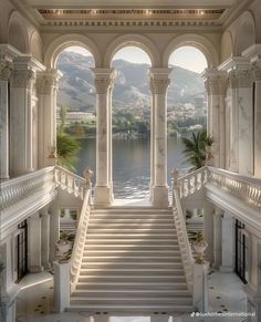 an ornate staircase leads up to the upper level of a building with large windows overlooking a body of water