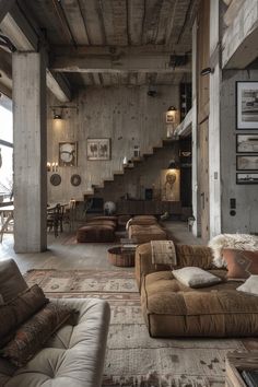 a living room filled with lots of furniture next to a stair case on the wall