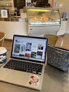 an open laptop computer sitting on top of a table next to a cup of coffee