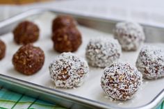 a metal tray filled with different types of chocolate truffles on top of a table