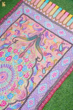 the colorful rug is laying on the grass