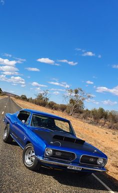 an old muscle car is parked on the side of the road