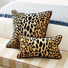 two leopard print pillows sitting on top of a bed