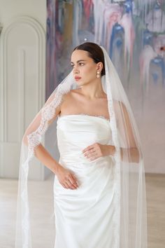 a woman in a white wedding dress and veil