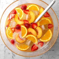 a glass bowl filled with ice and sliced fruit on top of a marble countertop