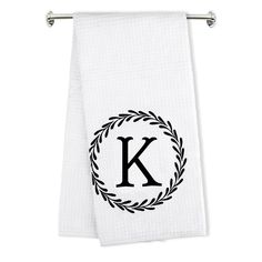 a white towel with the letter k on it and a laurel wreath in the middle