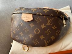 Overview Louis Vuitton Bum Bag in Canvas Monogram with gold hardware. Fashioned in classic Monogram canvas and signed with a “Louis Vuitton Paris” leather patch, this uber-functional bumbag transforms sportwear into the very definition of casual chic. Wear it as a belt bag, cross-body or over the shoulder for a jauntier look. This highly sought after style is no Longer available at LV and sells at premium usually. Features Monogram coated canvas Gold hardware Smooth cowhide leather trim Cotton c Bum Bag Louis Vuitton, Louis Vuitton Teddy Bumbag, Louis Vuitton Empreinte Bumbag, Louis Vuitton Bumbag, Louis Vuitton Bum Bag, Lv Bumbag, Monogram Neverfull, Vintage Louis Vuitton, Vuitton Bag