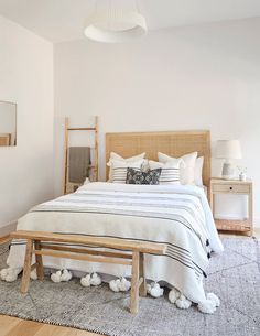 a bedroom with white walls and wooden furniture