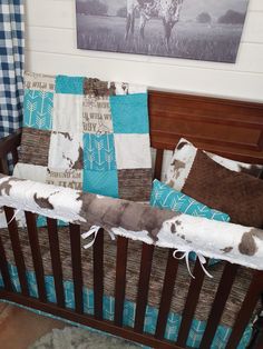 a baby crib with blue, brown and white bedding