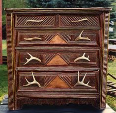 an old dresser with deer antlers painted on it