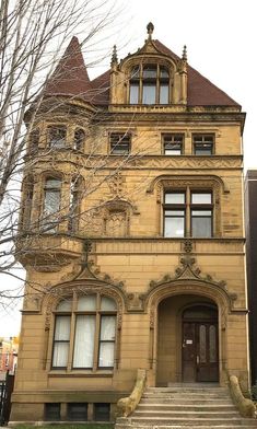 an old building with stairs leading up to the front door