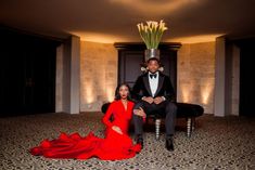 a man and woman in formal wear sitting on a chair