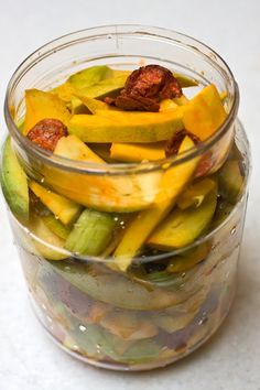 a glass jar filled with pickles and other vegetables