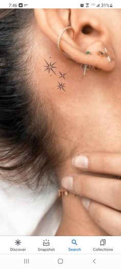 a woman has her ear pierced with small stars on it