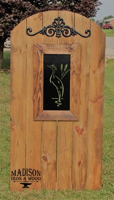 a wooden sign with an image of a bird on it's back and the words madison iron & wood