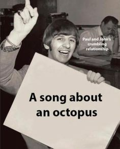 a man holding up a sign that says, a song about an octopus