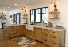 a large kitchen with wooden cabinets and white counter tops, along with open shelving on the wall