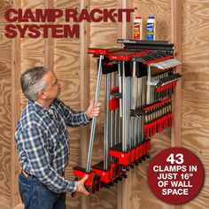 a man holding a tool rack in front of a wooden wall with the words clamp rack system on it