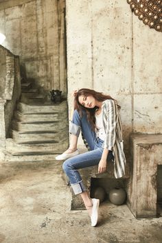 a woman is sitting on the steps in an abandoned building with her hand on her head