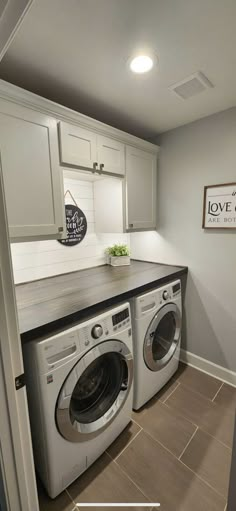 a washer and dryer in a laundry room with the words love at first written on the wall