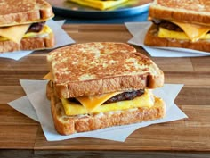 two grilled sandwiches with cheese and meat on them