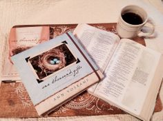 an open book sitting on top of a table next to a cup of coffee and two books