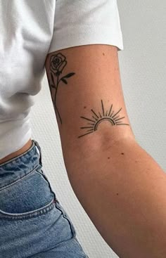 a woman's arm with a tattoo on it that has a sun and flowers