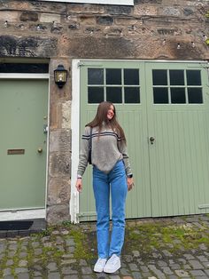 a woman standing in front of a green door