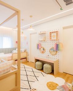 a child's bedroom with white walls and wooden floors, decorated in pastel colors