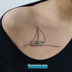 a woman with a small sailboat tattoo on her chest