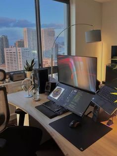 a desk with a laptop, keyboard and mouse on it in front of a large window