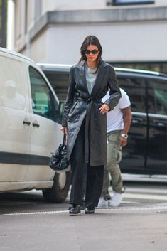 a woman walking down the street in front of a van